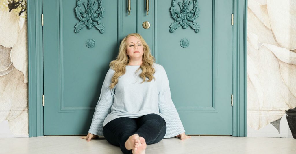 Lori Lynne Johnson Relaxing on Floor in Front of Blue Door