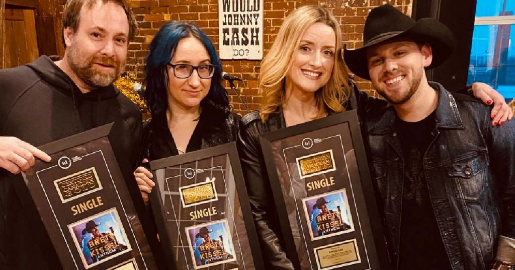 Karen Kosowski with other writers and Brett Kissel receiving plaques for a gold single