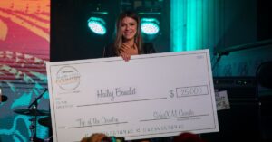 Hailey Benedict holds a big cheque after winning the Sirius XM Top of the country contest