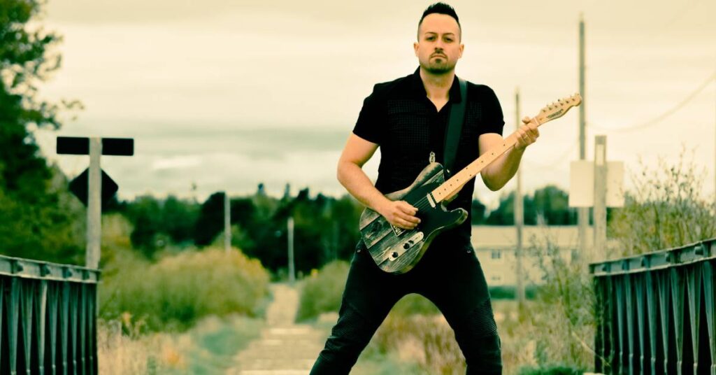 Jason Benoit Playing Guitar on a bridge