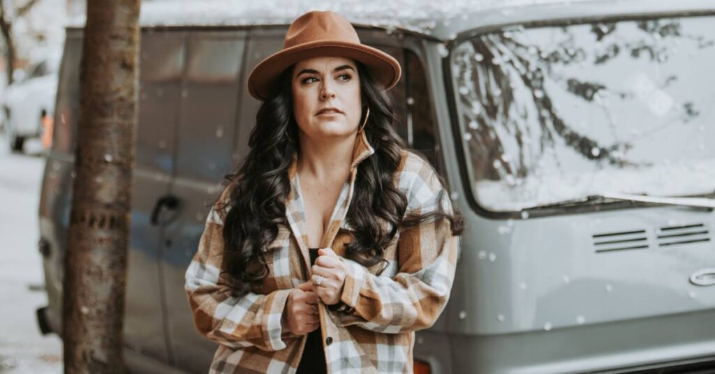 Justine Lynn - country artist standing in front of a vehicle